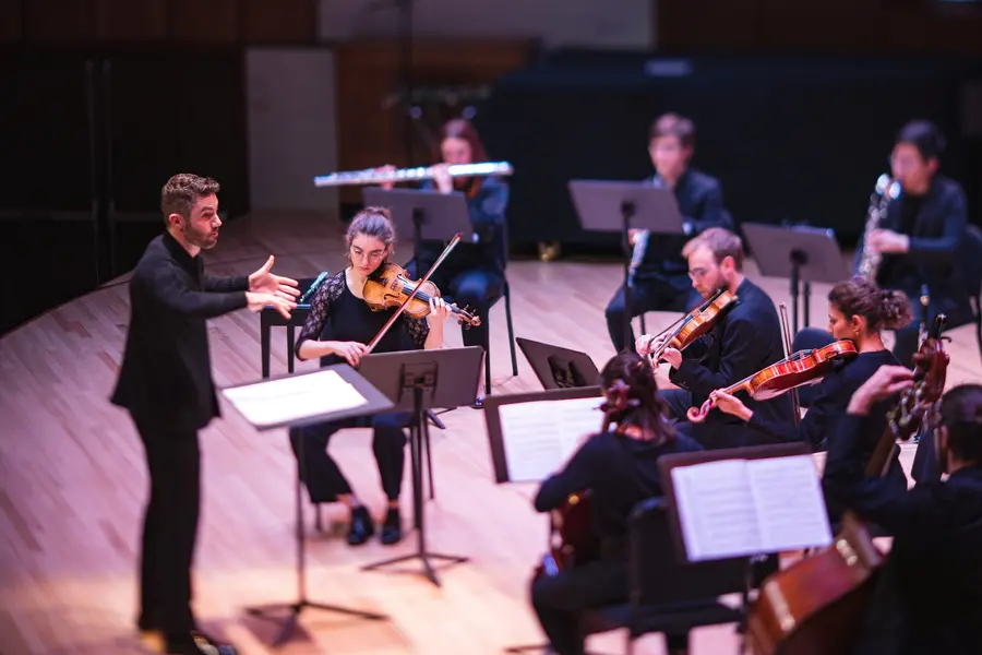 Photo of Jean-Michaël Lavoie conducting an ensemble on stage
